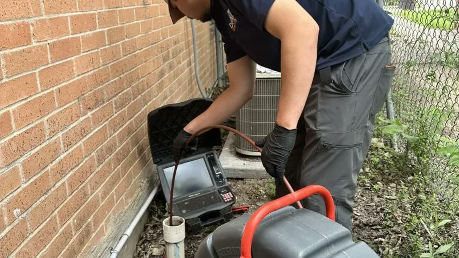 Camera inspection equipment in use at a residential drain cleanout